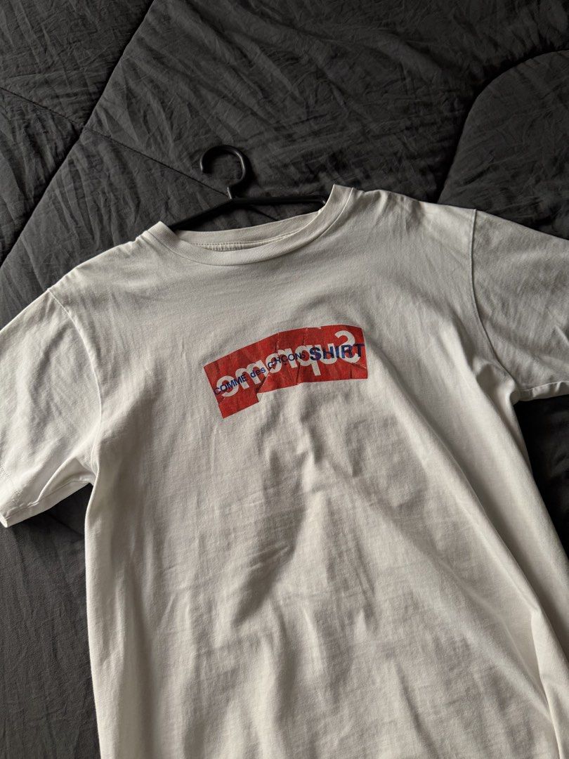 Supreme Comme des Garcons SHIRT Split Box Logo Tee (Category: Tshirts & Polo Shirts ) located in Cabanatuan. Submitted by archive.stuffz (Listing ID 1464971230, Image 2). Description: - Brand: Supreme x Comme des Garcons SHIRT - Color: White - Design: Iconic red and blue split box logo - Fit: Classic crew neck, short sleeves - Material: Comfortable cotton - Condition: Minor natural wear shown throughout, authentic hyped streetwear piece -SMALL .