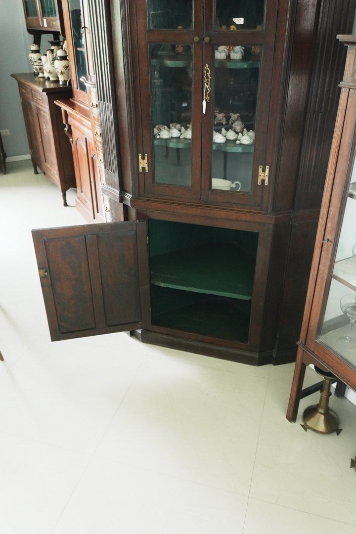 Tall Georgian - Style Corner Display Cabinet (Category: Shelves, Cabinets & Racks) located in Manila. Submitted by heleensym (Listing ID 1464971120, Image 3). Description: An impressive wooden corner cabinet featuring arched glass doors, fluted side columns and a decorative moulded cornice. The deep green interior has shaped display shelves, complemented by an enclosed lower cupboard for additional storage. A distinctive piece for displaying porc