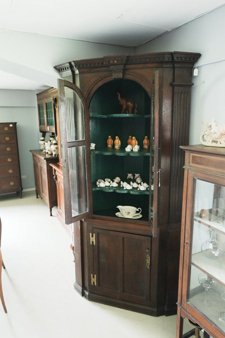 Tall Georgian - Style Corner Display Cabinet (Category: Shelves, Cabinets & Racks) located in Manila. Submitted by heleensym (Listing ID 1464971120, Image 2). Description: An impressive wooden corner cabinet featuring arched glass doors, fluted side columns and a decorative moulded cornice. The deep green interior has shaped display shelves, complemented by an enclosed lower cupboard for additional storage. A distinctive piece for displaying porc