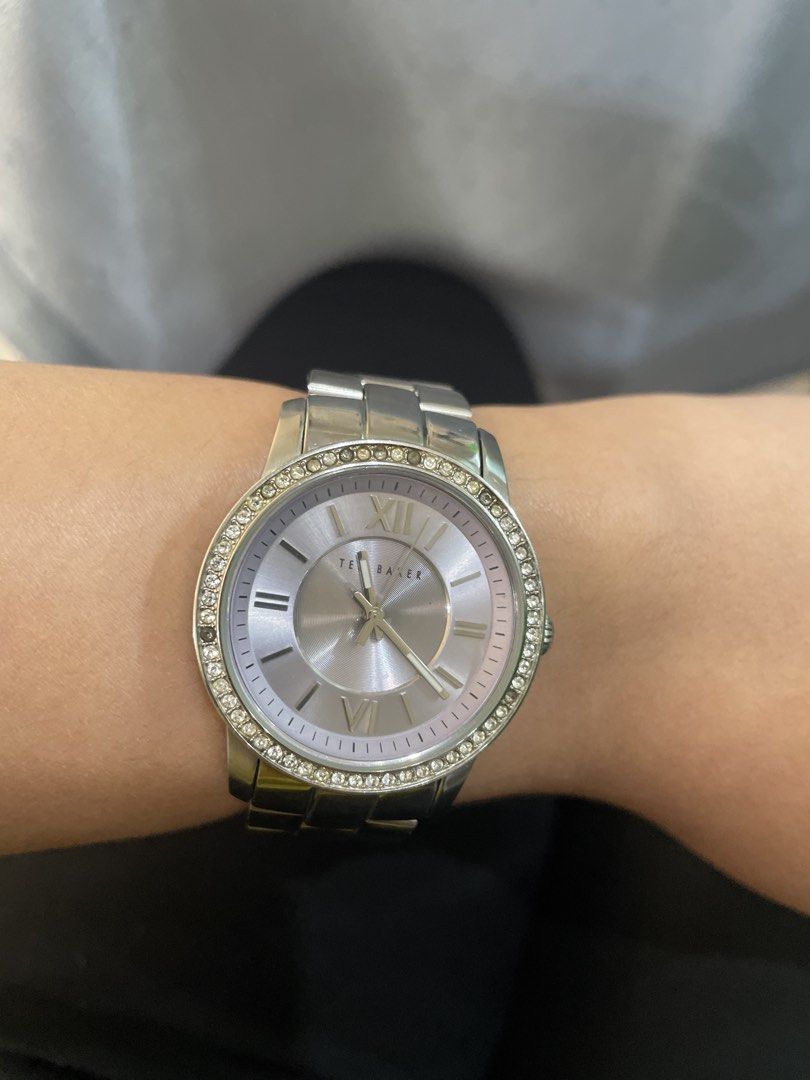 Ted Baker Silver Crystal Bezel Watch (Category: Women's Watches) located in Quezon City. Submitted by bhelditarose (Listing ID 1464990662, Image 1). Description: - Brand: Ted Baker - Color: Silver tone - Features: Round face with crystal-studded bezel, minimal dial markings, Roman numerals at 12 and 6 - Strap: Metallic link bracelet with simple clasp closure - Condition: Runs great, with normal minor scuffs from light use - Perfect for daily wear