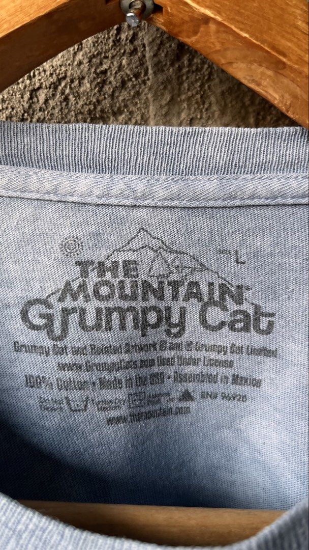 The Mountain Grumpy Cat Blue T-Shirt Size L (Category: Shirts) located in Cabuyao City. Submitted by bulandos (Listing ID 1465051827, Image 2). Description: - Design: Large Grumpy Cat portrait on the front with a light blue acid wash style - Size: Large (tag printed inside the collar) - Material: 100% classic heavy cotton for a comfortable, relaxed fit - Origin: Made in the USA with assembly in Mexico - Condition: Great quality graphic tee, perfe