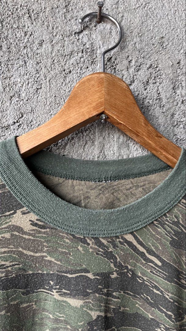 Tiger Stripe Camo Long Sleeve Shirt Crewneck (Category: Tshirts & Polo Shirts ) located in Cabuyao City. Submitted by bulandos (Listing ID 1465052182, Image 2). Description: - Design: Bold tiger stripe camouflage pattern all over - Style: Long sleeve crewneck with classic ribbed collar - Details: Contrast green ribbed trim on the neck and wrist cuffs - Condition: Shows some pilling throughout from regular wear and washing - Perfect for a rugged, 