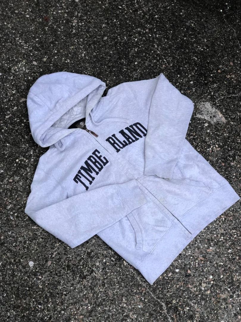 Timberland Grey Zip Hoodie (Category: Coats, Jackets and Outerwear) located in Tacloban City. Submitted by thedropout (Listing ID 1465053256, Image 1). Description: - Authentic Timberland grey zip-up hoodie - Size: Medium (Regular Fit) - Bold black letter branding across the front - Warm quilted hood lining with drawstring - Full zip closure with iconic tree-stamped leather pull - Convenient side pockets for daily essentials - Ribbed cuffs and he