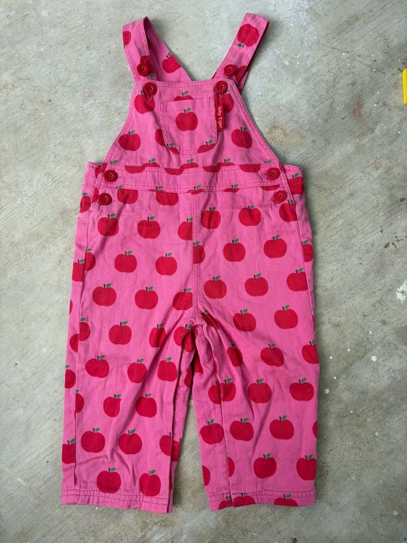 Toby Tiger Apple Print Pink Overalls (Category: Babies & Kids Fashion) located in Las Pinas. Submitted by pinkpototo36548 (Listing ID 1465071733, Image 1). Description: - Brand: Toby Tiger - Design: Pink overalls with all-over red apple print - Details: Red branded buttons on straps and sides - Pockets: Front chest pocket with red label tag and two back pockets - Style: Bright, playful, and comfortable for kids.