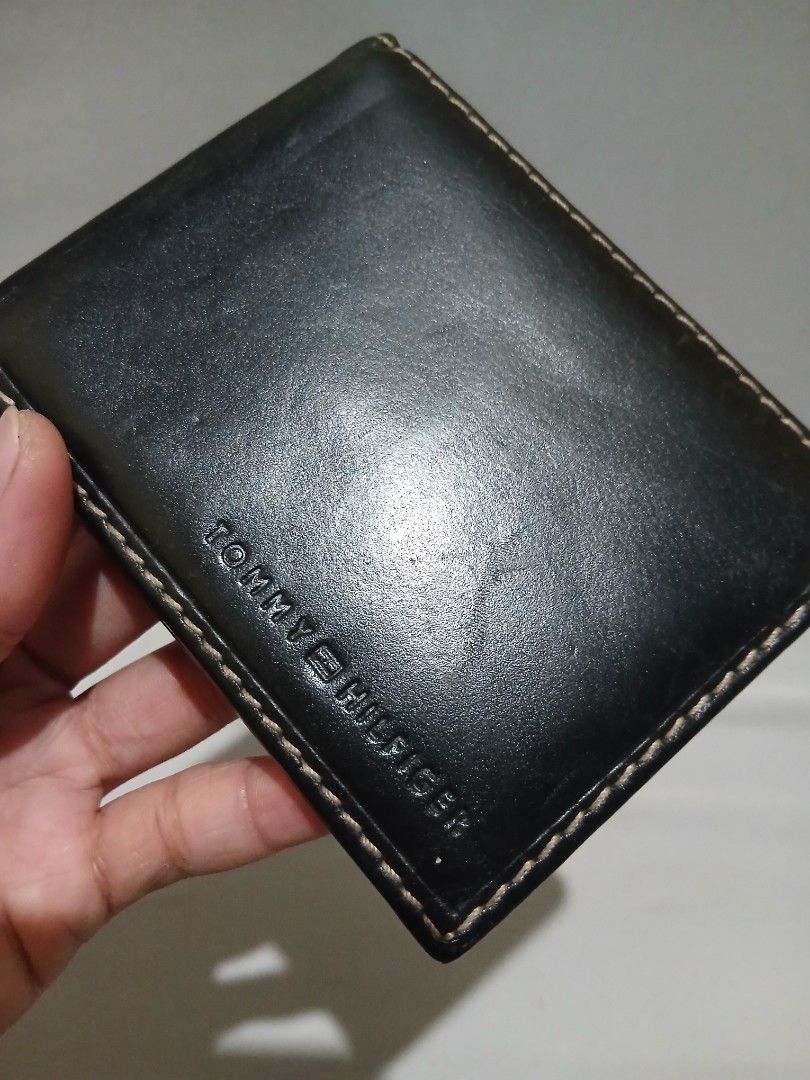 Tommy Hilfiger bifold wallet (Category: Wallets & Card holders) located in Bulacan. Submitted by assorted.items (Listing ID 1465036002, Image 3). Description: black leather Tommy Hilfiger bifold wallet featuring prominent contrast stitching and an embossed brand logo along the bottom edge..