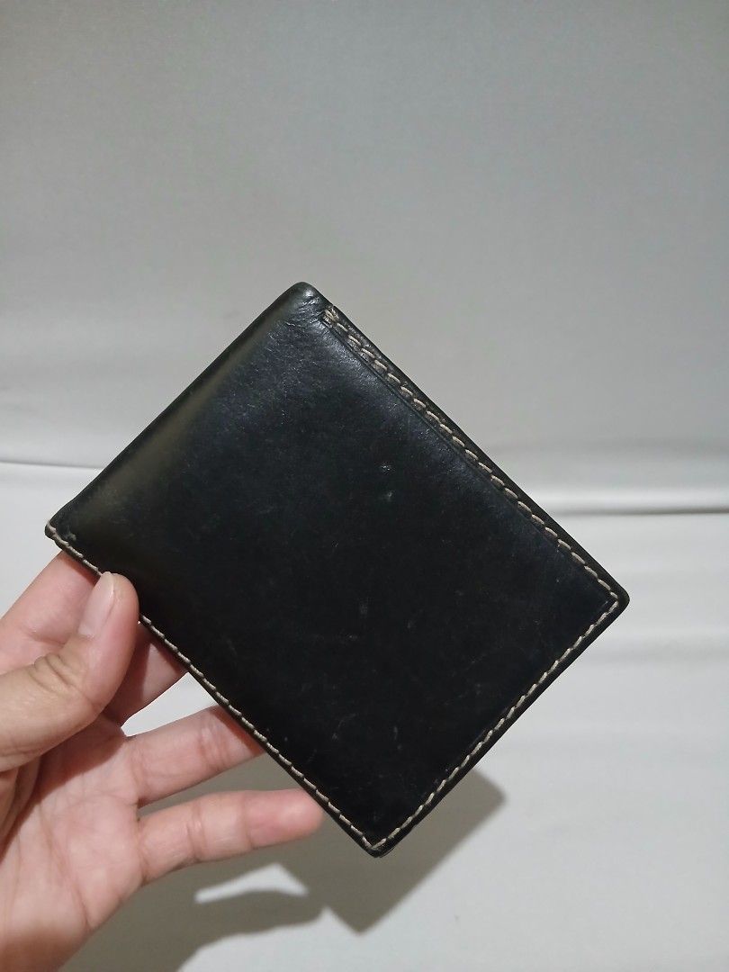 Tommy Hilfiger bifold wallet (Category: Wallets & Card holders) located in Bulacan. Submitted by assorted.items (Listing ID 1465036002, Image 2). Description: black leather Tommy Hilfiger bifold wallet featuring prominent contrast stitching and an embossed brand logo along the bottom edge..