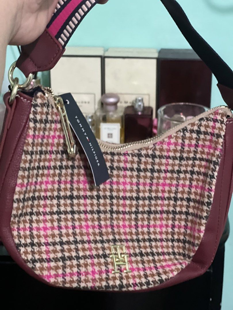 Tommy Hilfiger Houndstooth Shoulder Bag (Category: Shoulder Bags) located in Manila. Submitted by cleverstone_21f597 (Listing ID 1465098589, Image 1). Description: - Brand: Tommy Hilfiger - Pattern: Pink, brown, and black houndstooth tweed - Details: Burgundy leather trim and gold-tone hardware - Strap: Stylish patterned fabric shoulder strap - Closure: Top zip with branded pull - Condition: Pristine, clean interior and exterior with original bra
