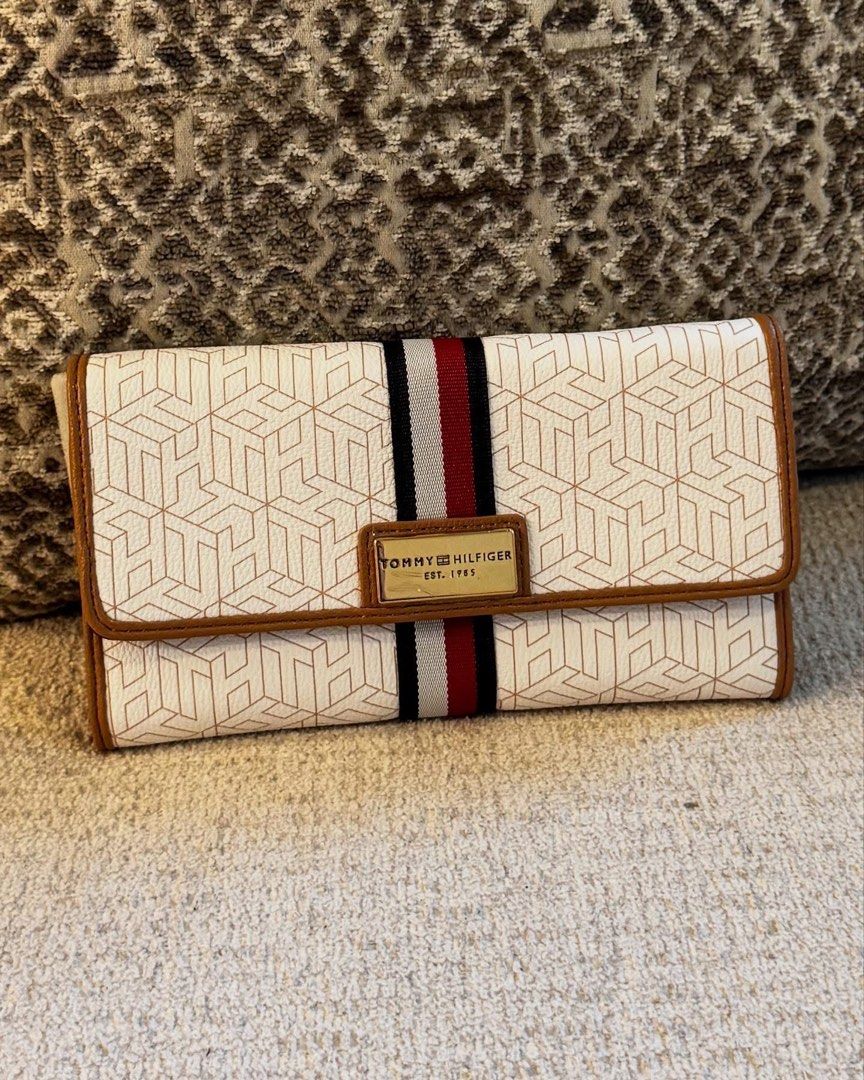 Tommy Hilfiger Monogram Long Wallet (Category: Wallets & Card holders) located in Manila. Submitted by luwiswisz (Listing ID 1465053492, Image 1). Description: - Brand: Tommy Hilfiger - Condition: Brand new with tag attached - Color/Pattern: White with geometric monogram, brown trim, and signature navy/white/red stripe - Hardware: Gold-tone with logo plate - Closure: Snap button - Interior: Multiple card slots, ID window, compartments, and black 