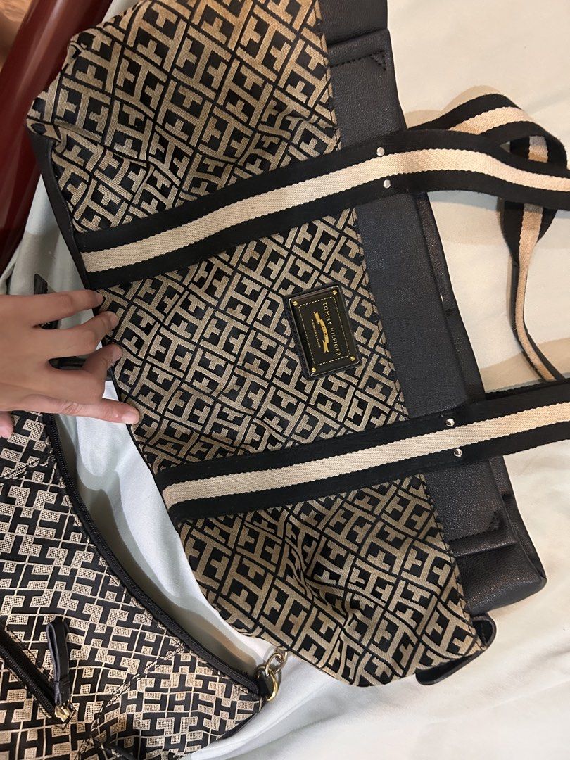 Tommy Hilfiger Monogram Tote Bag with Pouch (Category: Tote Bags) located in Quezon City. Submitted by retro_chic25 (Listing ID 1465087006, Image 1). Description: - Brand: Tommy Hilfiger - Set includes: Tote bag and matching small pouch - Design: Classic black and beige monogram pattern with black faux leather trim - Straps: Stylish striped shoulder straps with secure metal hardware - Interior: Navy lining, red-trimmed zip pocket, and red leather