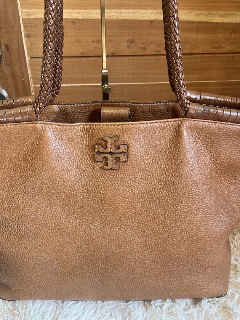 Tory Burch Pebbled Leather Tote Bag Brown (Category: Luxury Bags & Wallets) located in Cebu City. Submitted by nbetcuban007trendyfinds (Listing ID 1464971343, Image 2). Description: - Brand: Tory Burch, Large - Material: Genuine pebbled brown leather - Design: Braided shoulder handles, stitched top trim, and embossed iconic T logo on front - Interior: Patterned fabric lining with a secure zippered pocket - Closure: Magnetic snap closure - Conditi