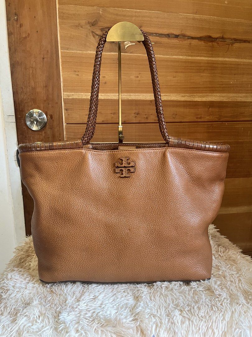 Tory Burch Pebbled Leather Tote Bag Brown (Category: Luxury Bags & Wallets) located in Cebu City. Submitted by nbetcuban007trendyfinds (Listing ID 1464971343, Image 1). Description: - Brand: Tory Burch, Large - Material: Genuine pebbled brown leather - Design: Braided shoulder handles, stitched top trim, and embossed iconic T logo on front - Interior: Patterned fabric lining with a secure zippered pocket - Closure: Magnetic snap closure - Conditi
