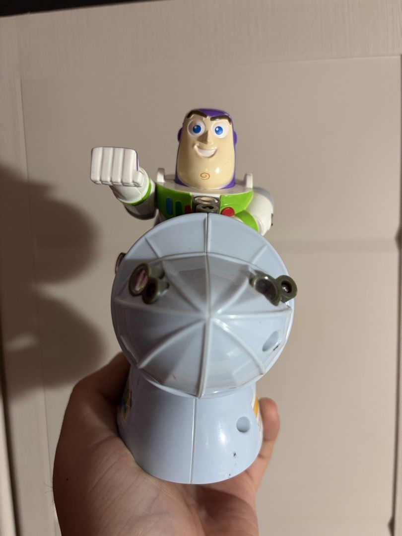 Toy Story Buzz Lightyear Rocket Ship Figure (Category: Figurines & Statues) located in Plaridel. Submitted by moddedjarvis (Listing ID 1465170087, Image 3). Description: - Character: Buzz Lightyear sitting on a blue rocket ship projector toy - Unique Details: Includes a 'Hammer Time' sticker on the base, lens details on the body, and a warning sticker on the back - Condition: Pre-loved, great display piece - Perfect For: Toy Story fans, kids, and