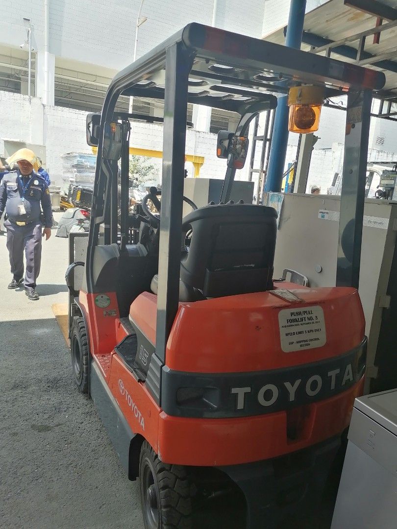 Toyota 1.5 Ton Forklift with Push-Pull Attachment (Category: Construction Tools & Equipment) located in Muntinlupa City. Submitted by fast_bryantorrentefernand (Listing ID 1464995307, Image 3). Description: NOW 350,000 WAS 500,000 - Brand/Model: Toyota Model 15 Forklift - Color: Bright orange and dark grey - Attachment: Push-pull slip-sheet attachment with long metal forks - Safety: Amber warning beacon light on overhead guard - Tires: Solid tire