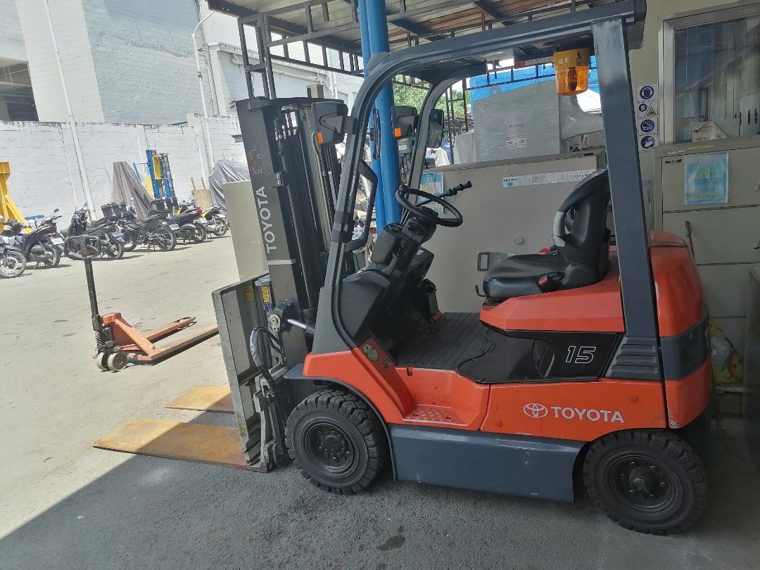 Toyota 1.5 Ton Forklift with Push-Pull Attachment (Category: Construction Tools & Equipment) located in Muntinlupa City. Submitted by fast_bryantorrentefernand (Listing ID 1464995307, Image 2). Description: NOW 350,000 WAS 500,000 - Brand/Model: Toyota Model 15 Forklift - Color: Bright orange and dark grey - Attachment: Push-pull slip-sheet attachment with long metal forks - Safety: Amber warning beacon light on overhead guard - Tires: Solid tire