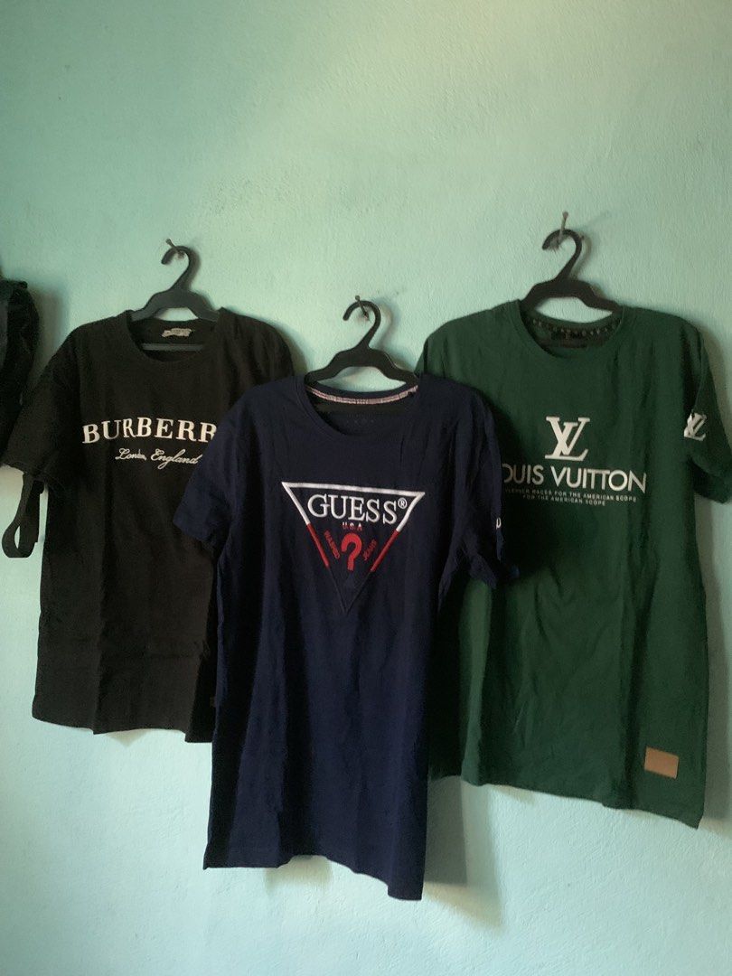 T-Shirts Bundle (Category: Tshirts & Polo Shirts ) located in Daraga. Submitted by ryrilim (Listing ID 1465026555, Image 2). Description: - Bundle of 3 designer-inspired tees (sell individually too) - Left: Black Burberry London England - Middle: Dark blue Guess USA triangle logo - Right: Green Louis Vuitton graphic with sleeve and hem patches - Material: Soft cotton - Fit: Standard crew neck - DM to buy separately or grab the whole bundle!.