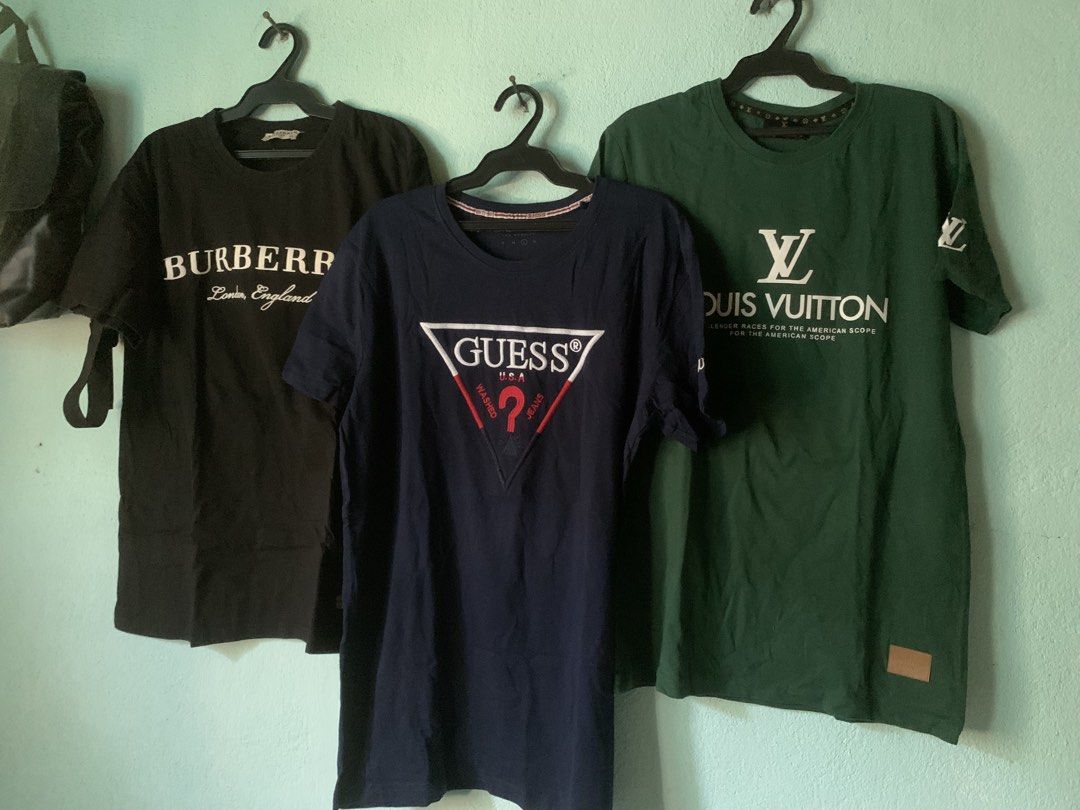 T-Shirts Bundle (Category: Tshirts & Polo Shirts ) located in Daraga. Submitted by ryrilim (Listing ID 1465026555, Image 1). Description: - Bundle of 3 designer-inspired tees (sell individually too) - Left: Black Burberry London England - Middle: Dark blue Guess USA triangle logo - Right: Green Louis Vuitton graphic with sleeve and hem patches - Material: Soft cotton - Fit: Standard crew neck - DM to buy separately or grab the whole bundle!.