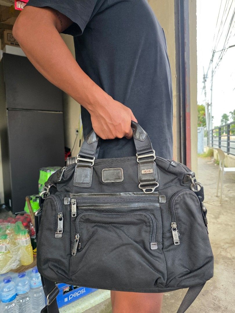 Tumi Black Nylon Briefcase Crossbody Bag (Category: Sling Bags) located in Lemery. Submitted by venus23 (Listing ID 1465098783, Image 1). Description: - Brand: Tumi - Material: Durable ballistic-style nylon with leather trim - Color: Classic Black - Dimensions: Approx. 14 inches across the bottom - Exterior: Multiple zipper pockets and compartments for easy organization - Carry Options: Sturdy leather top handles and a detachable shoulder strap -
