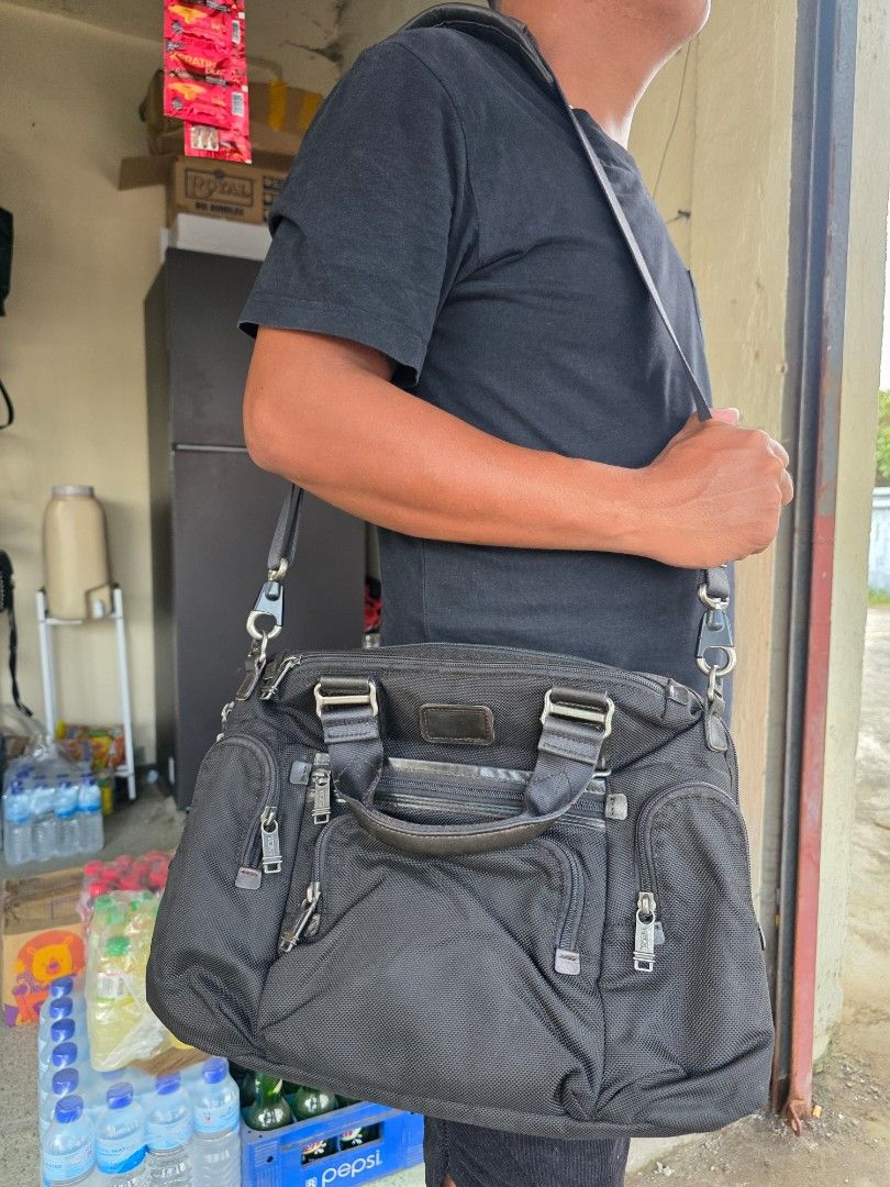 Tumi Black Nylon Briefcase Crossbody Bag (Category: Sling Bags) located in Lemery. Submitted by venus23 (Listing ID 1465098783, Image 2). Description: - Brand: Tumi - Material: Durable ballistic-style nylon with leather trim - Color: Classic Black - Dimensions: Approx. 14 inches across the bottom - Exterior: Multiple zipper pockets and compartments for easy organization - Carry Options: Sturdy leather top handles and a detachable shoulder strap -