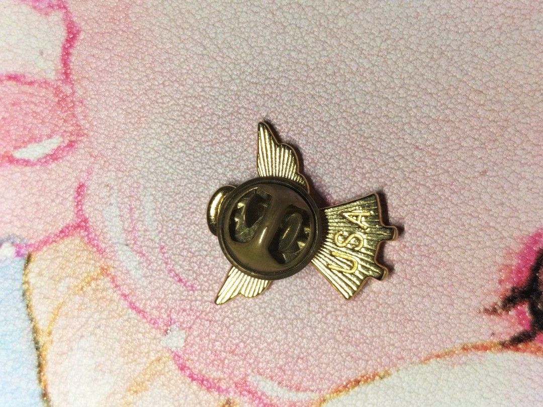 US Flag Angel Lapel Pin (Category: Brooches) located in Santa Ana. Submitted by erikarasu (Listing ID 1465048152, Image 2). Description: - Material & Design: Gold-tone metal angel pin with red, white, and blue enamel stars and stripes flag - Size: Small and lightweight, perfect for jackets, bags, caps, or lanyards - Closure: Secure standard butterfly clutch back with 'USA' stamp - Style: Great patriotic accessory for national holidays or daily we