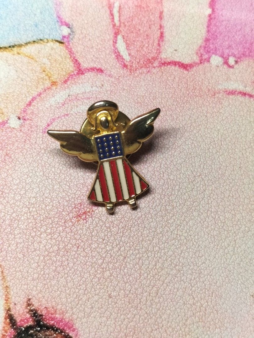 US Flag Angel Lapel Pin (Category: Brooches) located in Santa Ana. Submitted by erikarasu (Listing ID 1465048152, Image 1). Description: - Material & Design: Gold-tone metal angel pin with red, white, and blue enamel stars and stripes flag - Size: Small and lightweight, perfect for jackets, bags, caps, or lanyards - Closure: Secure standard butterfly clutch back with 'USA' stamp - Style: Great patriotic accessory for national holidays or daily we