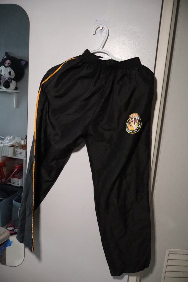UST PATHFIT Social Dance Pants (Category: Joggers) located in Manila. Submitted by leivic (Listing ID 1465061081, Image 1). Description: - Color: Black with stylish gold piping along the sides - Team Branding: UST Growling Tigers logo printed neatly near the left hip - Fit & Comfort: Comfortable elastic waistband for an easy, adjustable fit - Material: Lightweight fabric, perfect for casual wear or training - Condition: Good overall condition, cl