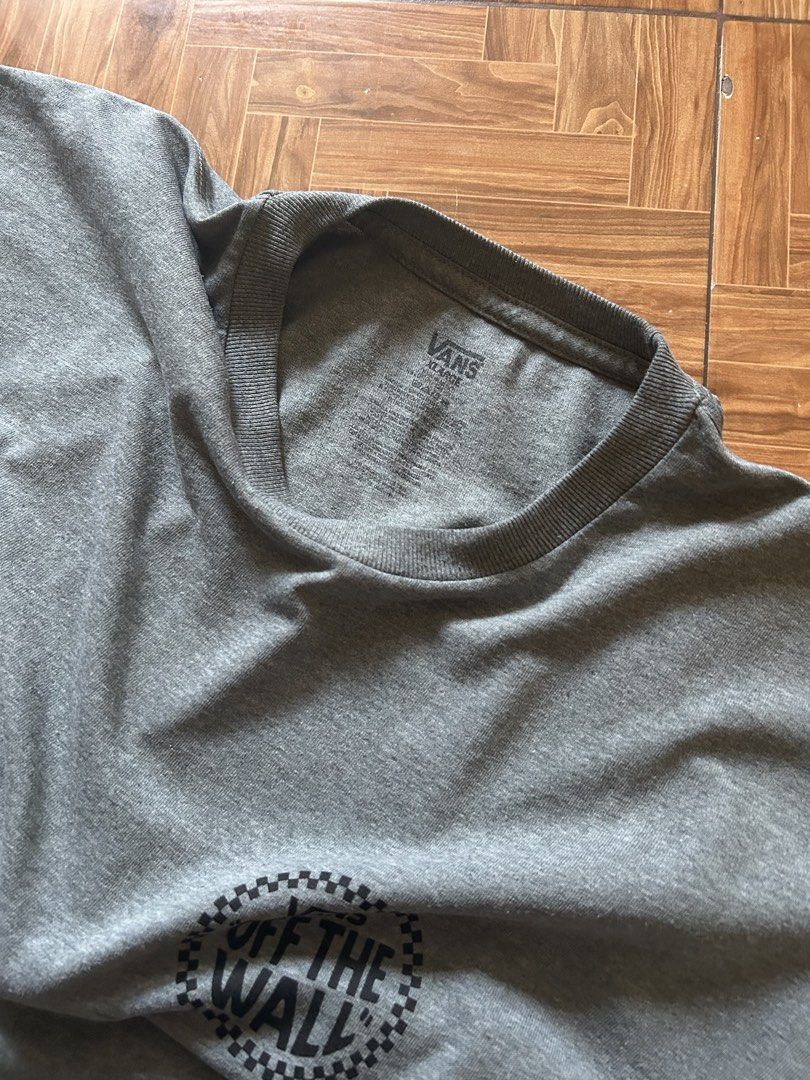 Vans Off The Wall Grey Graphic T-Shirt (Category: Tshirts & Polo Shirts ) located in San Fernando. Submitted by erison.cruz26 (Listing ID 1465020751, Image 3). Description: - Brand: Vans - Color: Grey - Size: XL - Fit: Relaxed fit with crew neck and short sleeves - Design: Small circular logo on front, large checkerboard graphic on the back - Condition: Easy everyday streetwear piece, pairs well with jeans or shorts - Dimension: 23*3.