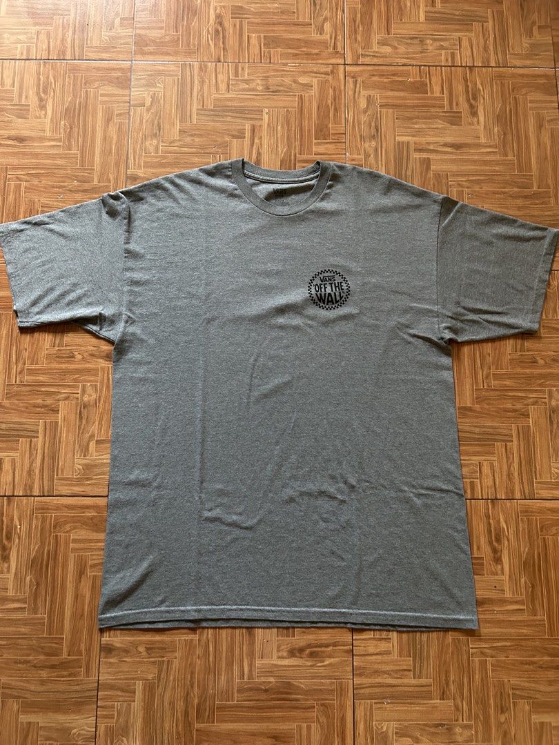 Vans Off The Wall Grey Graphic T-Shirt (Category: Tshirts & Polo Shirts ) located in San Fernando. Submitted by erison.cruz26 (Listing ID 1465020751, Image 1). Description: - Brand: Vans - Color: Grey - Size: XL - Fit: Relaxed fit with crew neck and short sleeves - Design: Small circular logo on front, large checkerboard graphic on the back - Condition: Easy everyday streetwear piece, pairs well with jeans or shorts - Dimension: 23*3.