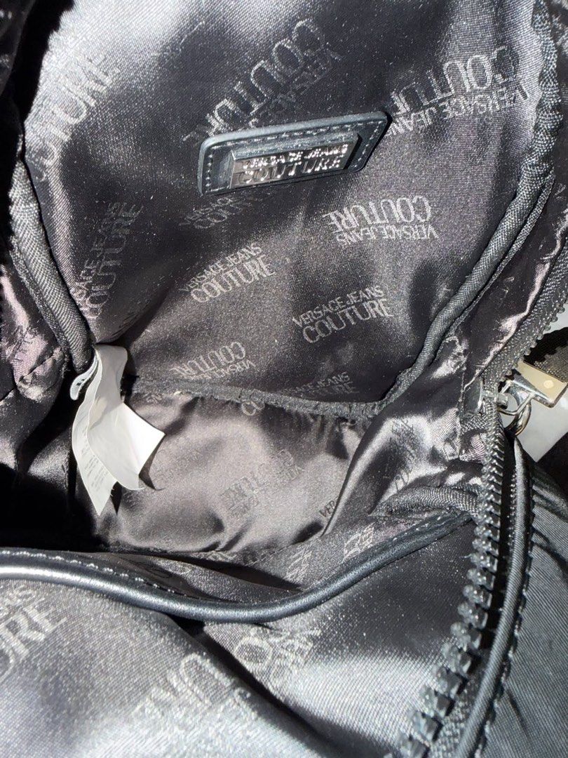 Versace Jeans Couture Nylon Backpack (Category: Luxury Bags & Wallets) located in Makati City. Submitted by konomi.phh (Listing ID 1465084393, Image 3). Description: - Brand: Versace Jeans Couture - Material: Durable black nylon with monogram fabric lining - Hardware: Silver metal logo plaque on front pocket - Straps: Adjustable branded webbing straps and top handle - Inclusions: Original dust bag and brand tags attached - Condition: Brand new - 