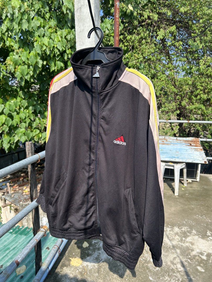 Vintage Adidas Black Track Jacket Size M (Category: Coats, Jackets and Outerwear) located in Cebu City. Submitted by purephoenix-2e10a3 (Listing ID 1464972971, Image 3). Description: - Brand: Adidas - Style: Black track jacket with beige chest and shoulder panels - Details: Colorful stripes on sleeves, red embroidered Adidas logo - Hardware: Custom metal zipper pull shaped like the Adidas trefoil logo - Size: Medium - Features: Full zip closure, 