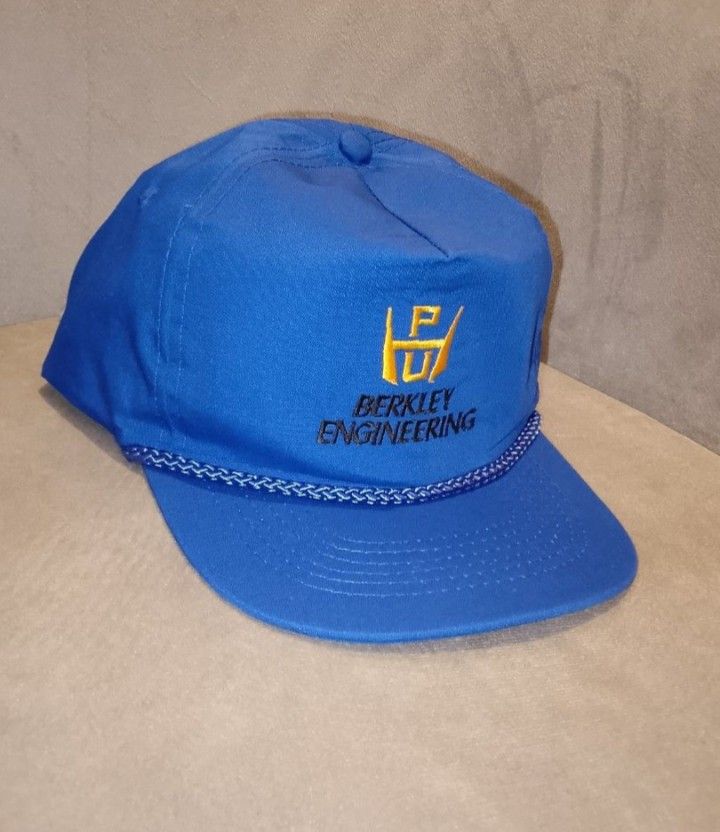 Vintage Berkley Engineering Snapback Hat, Blue with Yellow Logo (Category: Caps & Hats) located in Binangonan. Submitted by yuristalin888 (Listing ID 1464973369, Image 3). Description: This vintage blue snapback hat features the "Berkley Engineering" logo embroidered in yellow on the front. The hat has a classic five-panel construction with a rope detail across the brim. It is made of a sturdy fabric and includes an adjustable strap and brass-ton