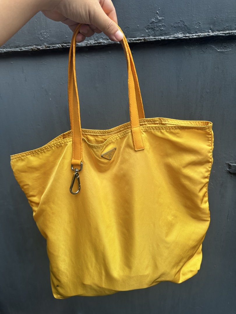 Vintage Prada Yellow Nylon Tote Bag (Category: Luxury Bags & Wallets) located in Quezon City. Submitted by la.deals (Listing ID 1465022263, Image 1). Description: - Brand: Prada - Material: Classic nylon with leather handles - Color: Bright yellow - Hardware: Lampo zipper closure - Features: Signature triangle logo plaque, interior pocket, and inner leather logo tag - Authenticity marker: Small white tag with number 58 inside - Condition: Noticea
