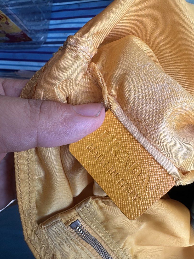 Vintage Prada Yellow Nylon Tote Bag (Category: Luxury Bags & Wallets) located in Quezon City. Submitted by la.deals (Listing ID 1465022263, Image 3). Description: - Brand: Prada - Material: Classic nylon with leather handles - Color: Bright yellow - Hardware: Lampo zipper closure - Features: Signature triangle logo plaque, interior pocket, and inner leather logo tag - Authenticity marker: Small white tag with number 58 inside - Condition: Noticea