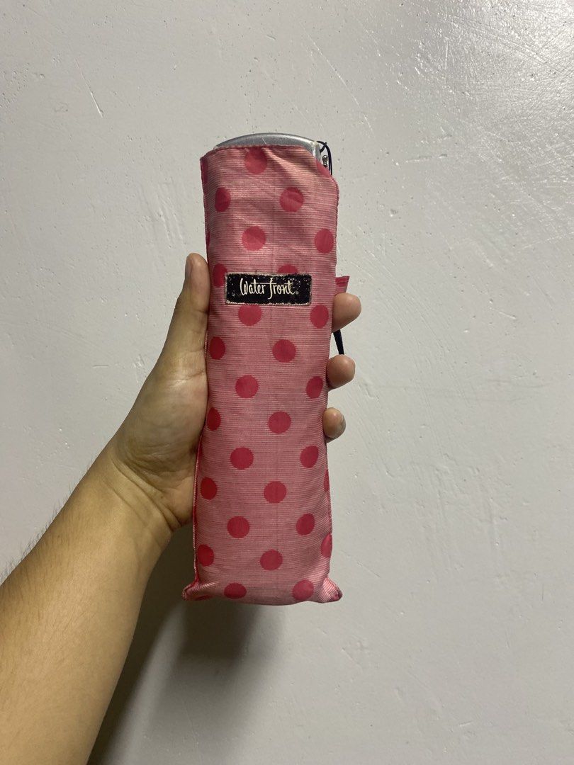 Waterfront Pink Polka Dot Foldable Umbrella (Category: Umbrellas) located in Pasacao. Submitted by wengpullar37205 (Listing ID 1465097069, Image 1). Description: - Brand: Waterfront - Color/Pattern: Pink with all-over polka dots - Features: Compact size, fits easily into bags, fully functional open and close mechanism - Inclusion: Matching sleeve with branded tag - Flaw: Minor rust stains near the ribs from previous use (kindly check the pictures