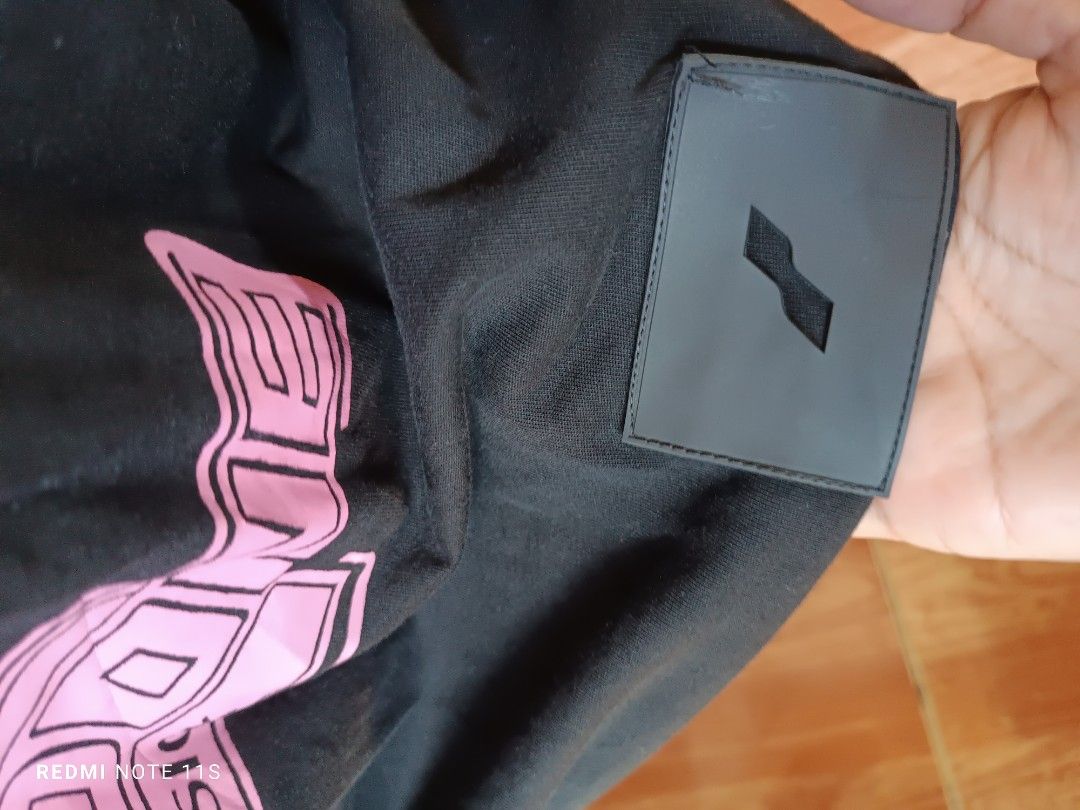 WE11DONE Homesick Black T-Shirt (Category: Tshirts & Polo Shirts ) located in Gapan. Submitted by thrift2heaven (Listing ID 1465088344, Image 3). Description: Black WE11DONE t-shirt with multicolored Homesick text graphics stacked on the back. Small pink logo patch on the chest. Ribbed crew neckline and rubber brand label near the hem. Inner collar tag and authenticity QR code label attached. Relaxed fit style..
