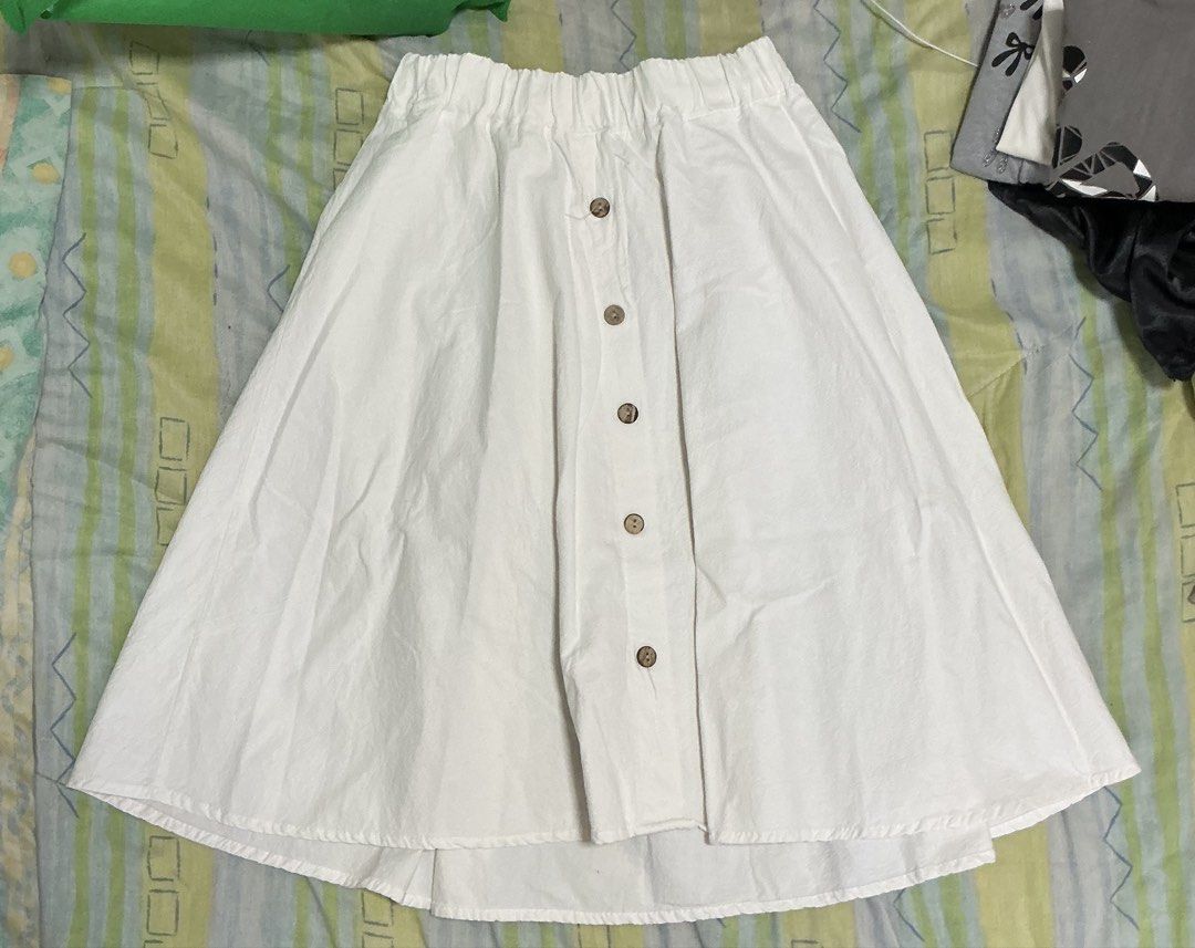 White Midi Skirt with Front Buttons Elastic Waist (Category: Skirts) located in Manila. Submitted by mornight736 (Listing ID 1465007740, Image 1). Description: - Size: Can fit S to L - Garterized - Color: White - Material: Lightweight cotton blend - Length: Midi - Details: Front row of brown wooden buttons, comfy elastic waistband - MOP: Gcash + SF - SF is shouldered by buyer .