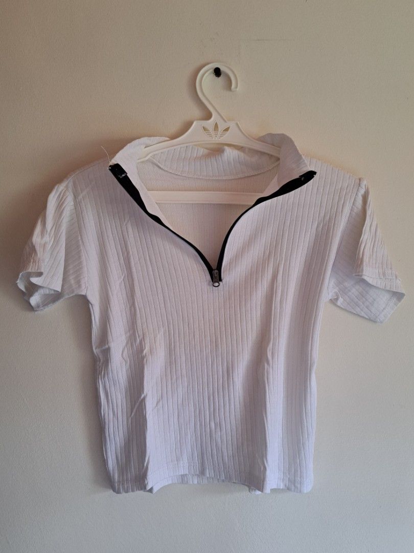 White Ribbed Half-Zip Short Sleeve Top (Category: Shirts) located in Manila. Submitted by yselles__ (Listing ID 1464980923, Image 1). Description: - Color: White - Style: Short sleeve ribbed top with deep half-zip closure - Material: Stretchy fabric (slight sheerness when stretched) - Fit: Standard fit, comfortable for daily wear - Versatility: Easily pairs with jeans or skirts.