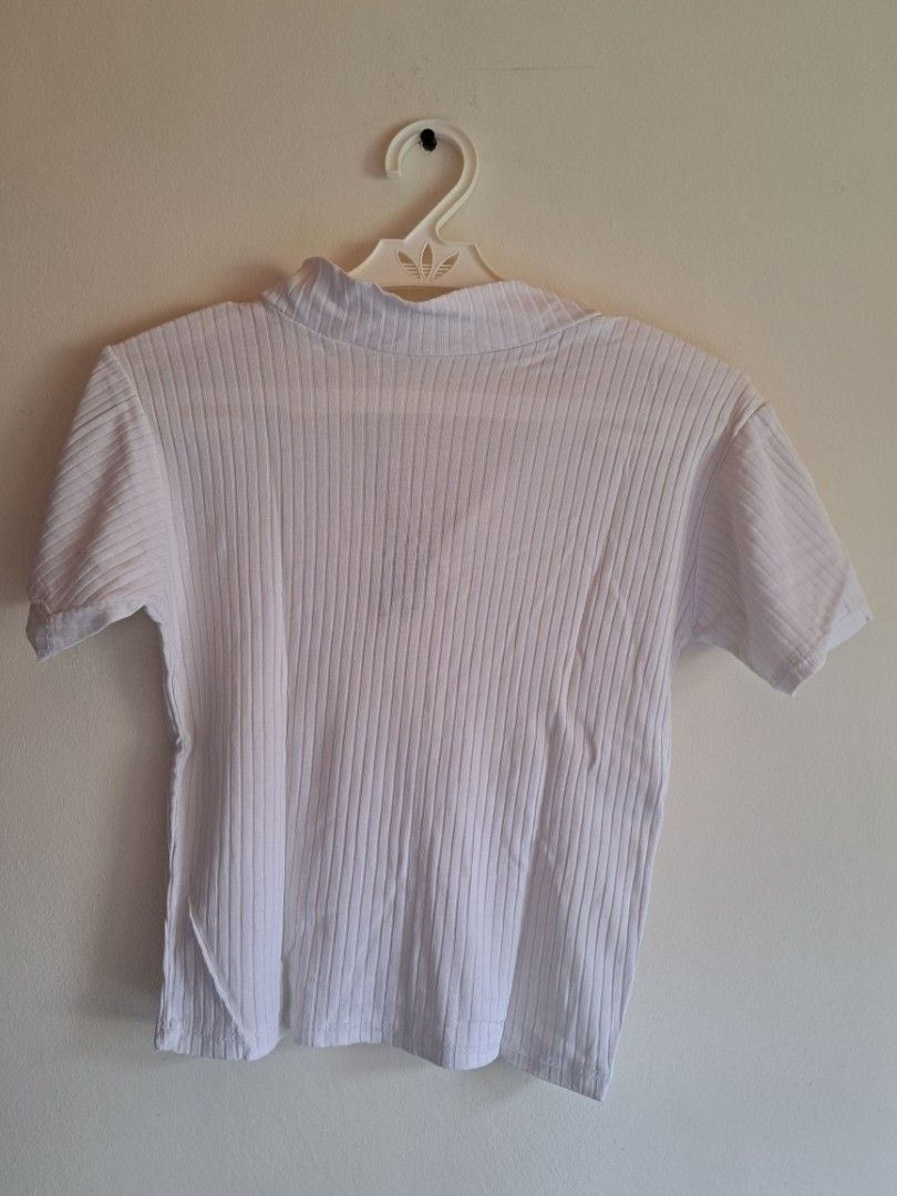 White Ribbed Half-Zip Short Sleeve Top (Category: Shirts) located in Manila. Submitted by yselles__ (Listing ID 1464980923, Image 2). Description: - Color: White - Style: Short sleeve ribbed top with deep half-zip closure - Material: Stretchy fabric (slight sheerness when stretched) - Fit: Standard fit, comfortable for daily wear - Versatility: Easily pairs with jeans or skirts.