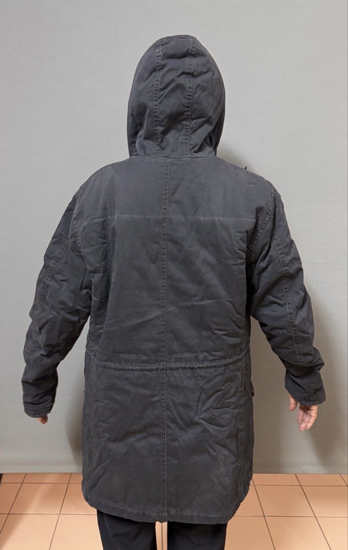Winter jacket (Category: Coats, Jackets and Outerwear) located in Petaling Jaya. Submitted by cheongyerdua (Listing ID 1465007372, Image 2). Description: a military-style canvas fishtail parka in black (or very dark charcoal faded navy). The design matches a classic M-51 fishtail silhouette, featuring: • A large drawstring hood • An adjustable waist drawstring • Angled flap pockets on the lower front • Mid-thigh utility length.