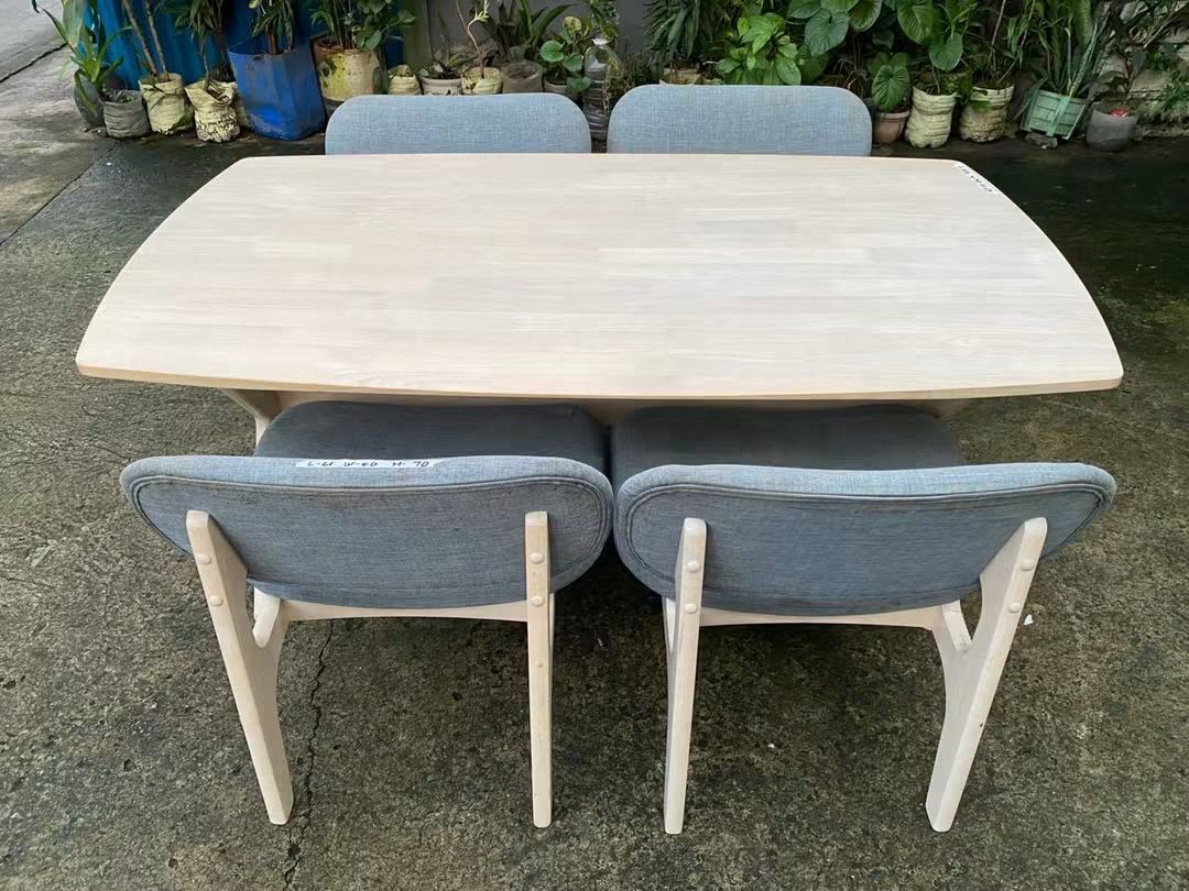 Wooden Dining Table with 4 Blue Cushioned Chairs (Category: Tables & Sets) located in Makati City. Submitted by candyhinojales (Listing ID 1464969189, Image 1). Description: - Set includes: 1 wooden dining table and 4 matching chairs - Table design: Light wood finish with a unique cross-leg base - Chair details: Wooden frames with comfortable soft blue fabric upholstery - Style: Clean, modern look ideal for dining rooms or kitchens - Condition/Bu