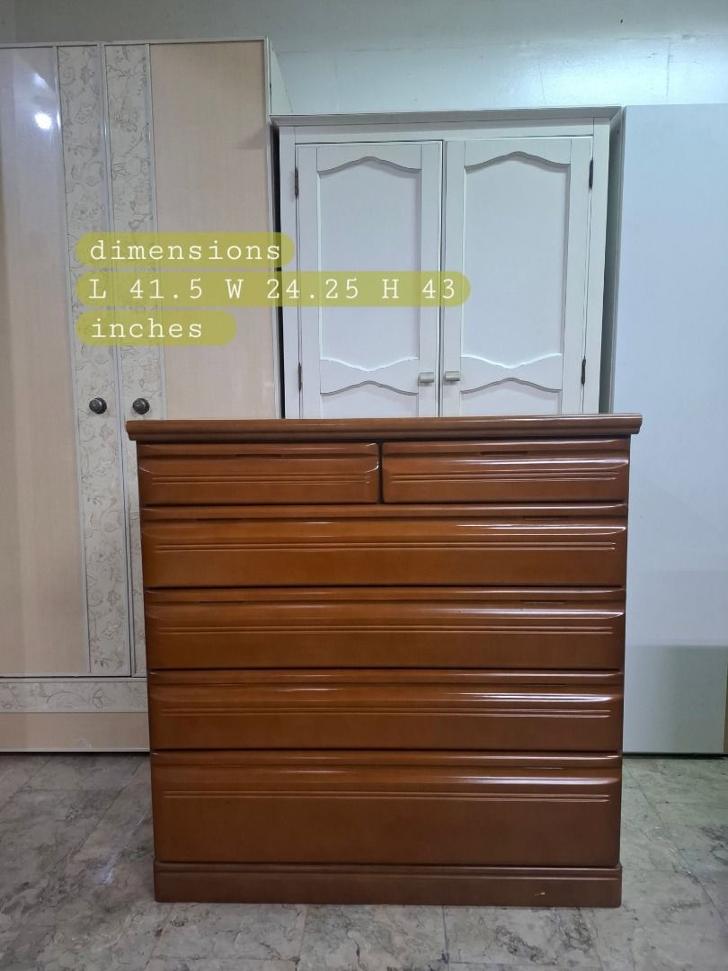 Wooden dresser with multiple pull-out drawers (Category: Shelves, Cabinets & Racks) located in Quezon City. Submitted by japandemanila (Listing ID 1465006993, Image 1). Description: - Warm medium-brown wooden chest of drawers - Ample storage with 2 small top drawers and 4 wider bottom drawers - Clean wooden interior linings in every drawer - Smooth polished top surface - Sturdy build featuring classic carved accent lines on each drawer front - Id