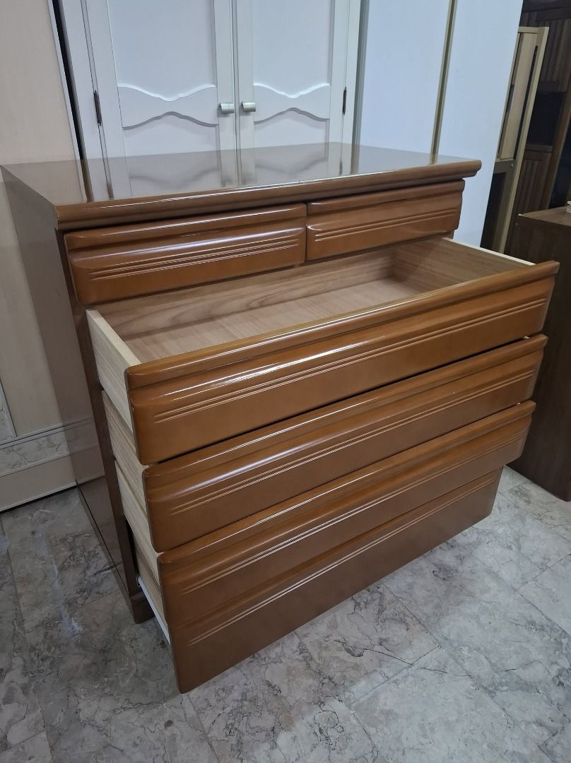 Wooden dresser with multiple pull-out drawers (Category: Shelves, Cabinets & Racks) located in Quezon City. Submitted by japandemanila (Listing ID 1465006993, Image 2). Description: - Warm medium-brown wooden chest of drawers - Ample storage with 2 small top drawers and 4 wider bottom drawers - Clean wooden interior linings in every drawer - Smooth polished top surface - Sturdy build featuring classic carved accent lines on each drawer front - Id