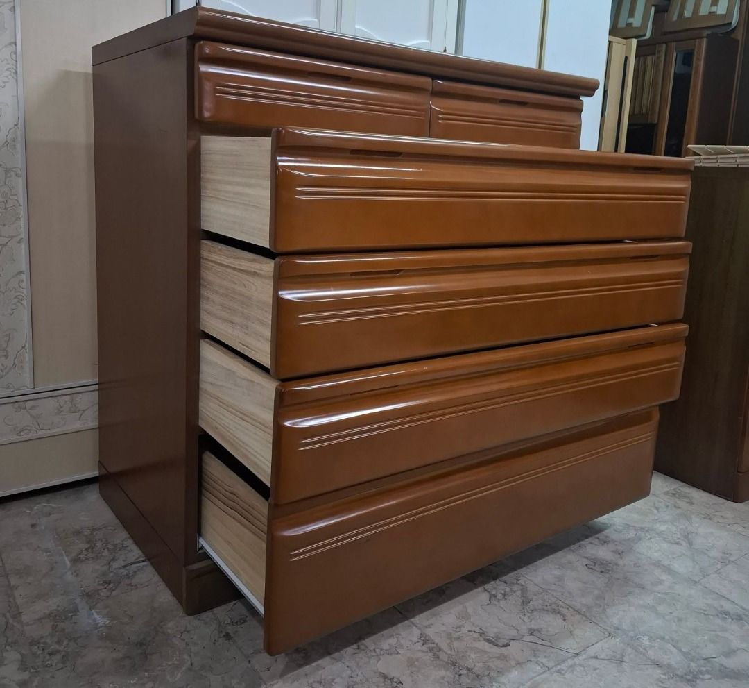 Wooden dresser with multiple pull-out drawers (Category: Shelves, Cabinets & Racks) located in Quezon City. Submitted by japandemanila (Listing ID 1465006993, Image 3). Description: - Warm medium-brown wooden chest of drawers - Ample storage with 2 small top drawers and 4 wider bottom drawers - Clean wooden interior linings in every drawer - Smooth polished top surface - Sturdy build featuring classic carved accent lines on each drawer front - Id