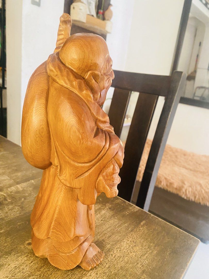Wooden Laughing Buddha Statue (Category: Figurines & Statues) located in San Jose del Monte. Submitted by cityhanter007 (Listing ID 1465003257, Image 3). Description: - Type: Hand-carved wooden Laughing Buddha statue - Size: Approximately 11 inches tall - Details: Features flowing robes, detailed facial expression, large sack, and staff - Finish: Warm wood grain with a smooth, polished surface - Placement: Ideal accent decor for shelves, accent t