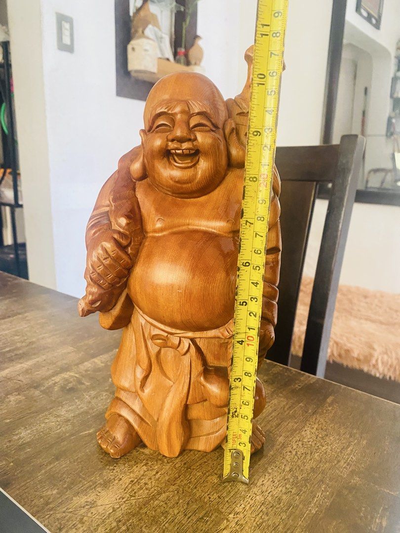 Wooden Laughing Buddha Statue (Category: Figurines & Statues) located in San Jose del Monte. Submitted by cityhanter007 (Listing ID 1465003257, Image 2). Description: - Type: Hand-carved wooden Laughing Buddha statue - Size: Approximately 11 inches tall - Details: Features flowing robes, detailed facial expression, large sack, and staff - Finish: Warm wood grain with a smooth, polished surface - Placement: Ideal accent decor for shelves, accent t