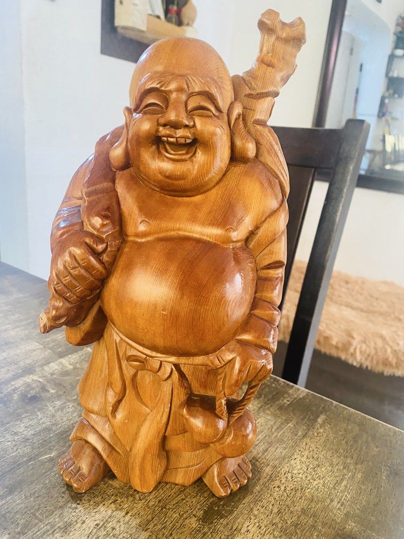 Wooden Laughing Buddha Statue (Category: Figurines & Statues) located in San Jose del Monte. Submitted by cityhanter007 (Listing ID 1465003257, Image 1). Description: - Type: Hand-carved wooden Laughing Buddha statue - Size: Approximately 11 inches tall - Details: Features flowing robes, detailed facial expression, large sack, and staff - Finish: Warm wood grain with a smooth, polished surface - Placement: Ideal accent decor for shelves, accent t
