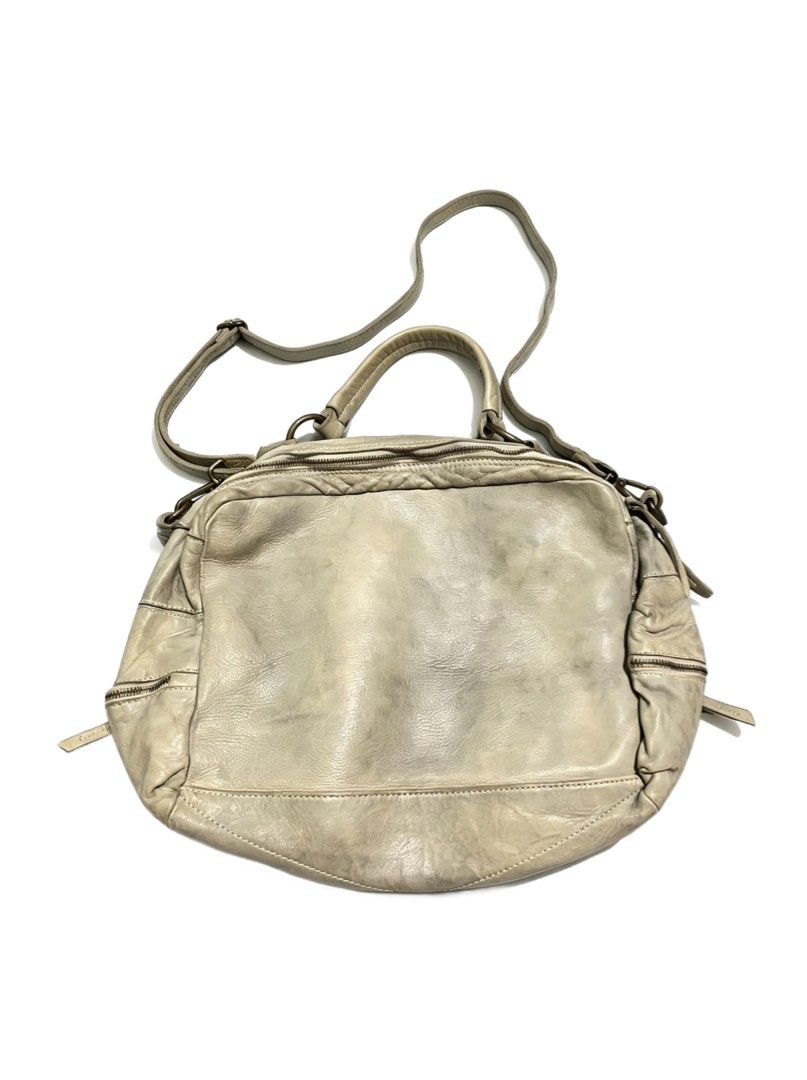 Woven Leather Shoulder Bag (Category: Shoulder Bags) located in Quezon City. Submitted by un0oo (Listing ID 1465013570, Image 2). Description: - Color: Grey - Material: Genuine leather with a distressed finish - Design: Woven pattern on the front panel and smooth leather back with natural shading - Straps: Dual top handles and a long adjustable strap - Compartments: Secure zipper closures on the main compartment and side pockets.
