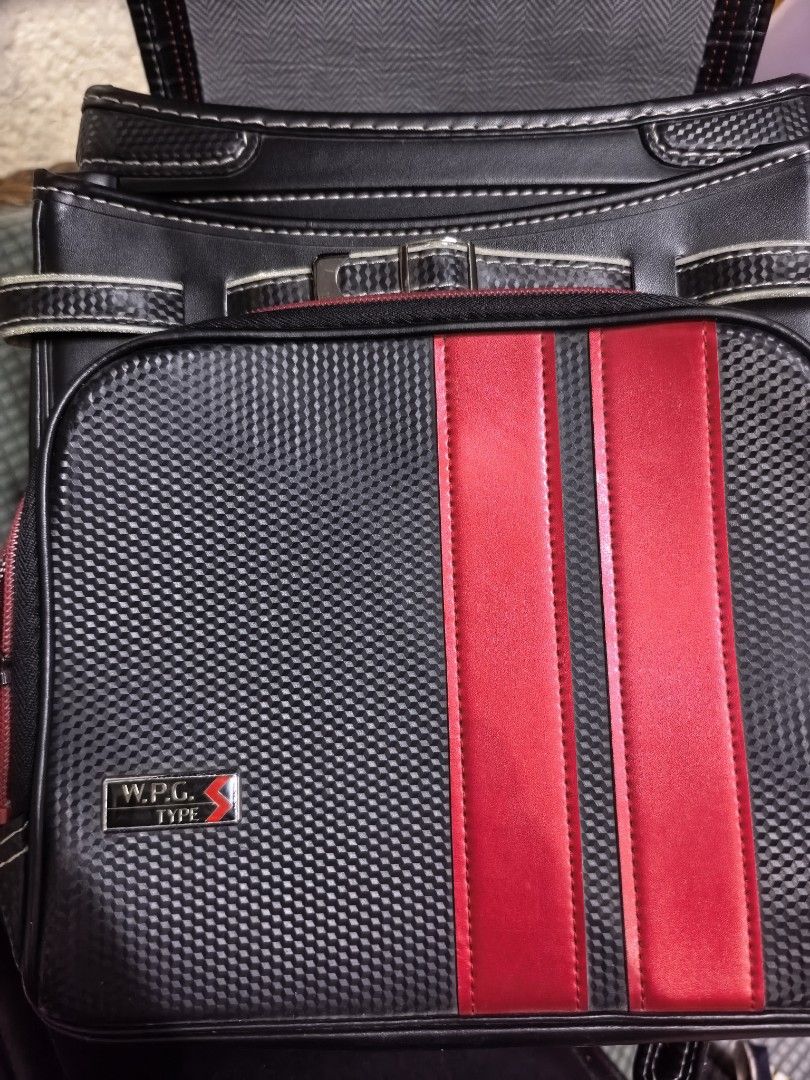 W.P.G. Type Black and Red School Backpack Satchel (Category: Backpacks) located in Rizal. Submitted by gkstcenit (Listing ID 1465059486, Image 2). Description: - Color: Black and red with textured carbon pattern - Accents: Red stripe details with W.P.G. Type label and metal shield emblems - Closure: Front flap with secure buckle strap - Storage: Spacious main compartment with chevron pattern lining - Extra Features: Exterior pocket with a clear I