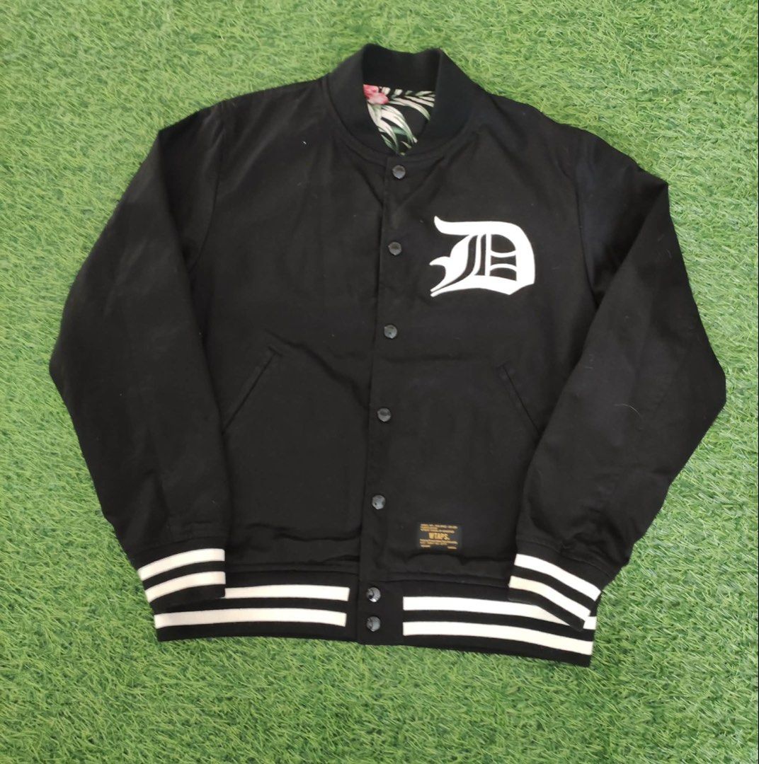 WTAPS Reversible Varsity Jacket Black Floral (Category: Coats, Jackets and Outerwear) located in Makati City. Submitted by rare_thrift_stuff (Listing ID 1464974636, Image 1). Description: - Brand: WTAPS -Dimension 21/24 - Style: Reversible varsity jacket - Side A: Solid black with white 'D' chest patch and striped ribbed trim - Side B: Full tropical flower and leaf print - Closure: Snap buttons down the front - Pockets: Two hand pockets on both s