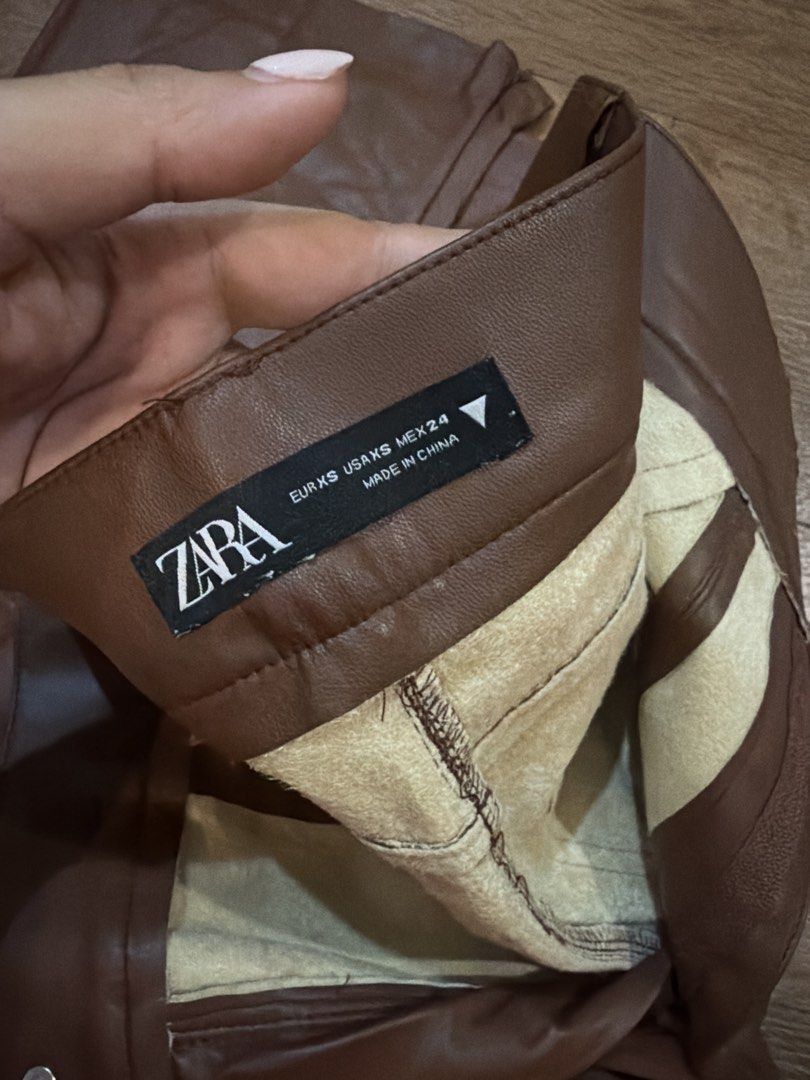 Zara Brown Faux Leather Pants (Category: Jeans) located in Paranaque City. Submitted by TrendyBoutique.ph (Listing ID 1465016258, Image 2). Description: - Brand: Zara - Size: EUR XS, US XS, MEX 24 - Color: Brown - Material: Faux leather with cozy fleece lining - Fit: High-rise waist with button closure - Origin: Made in China - Condition/Vibe: Great staple piece for autumn and winter outfits.