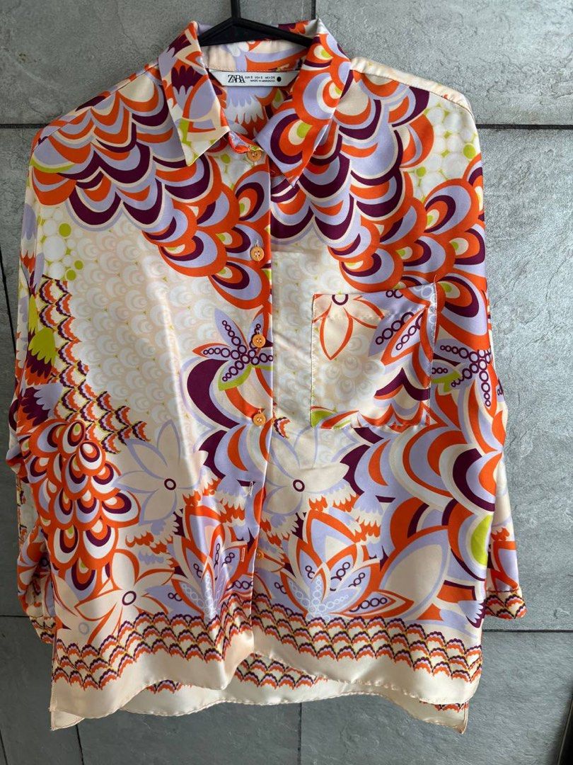 Zara Retro Floral Print Button-Down Shirt Size S (Category: Blouses) located in Taguig. Submitted by anxmz (Listing ID 1465043381, Image 1). Description: - Brand: Zara - Design: 70s-style abstract floral print - Colors: Orange, purple, lilac, and cream - Details: Collared neckline, front button closure, one chest pocket - Fabric: Silky, lightweight, and flowy - Origin: Made in Morocco - Condition/Use: Great statement piece for everyday wear.
